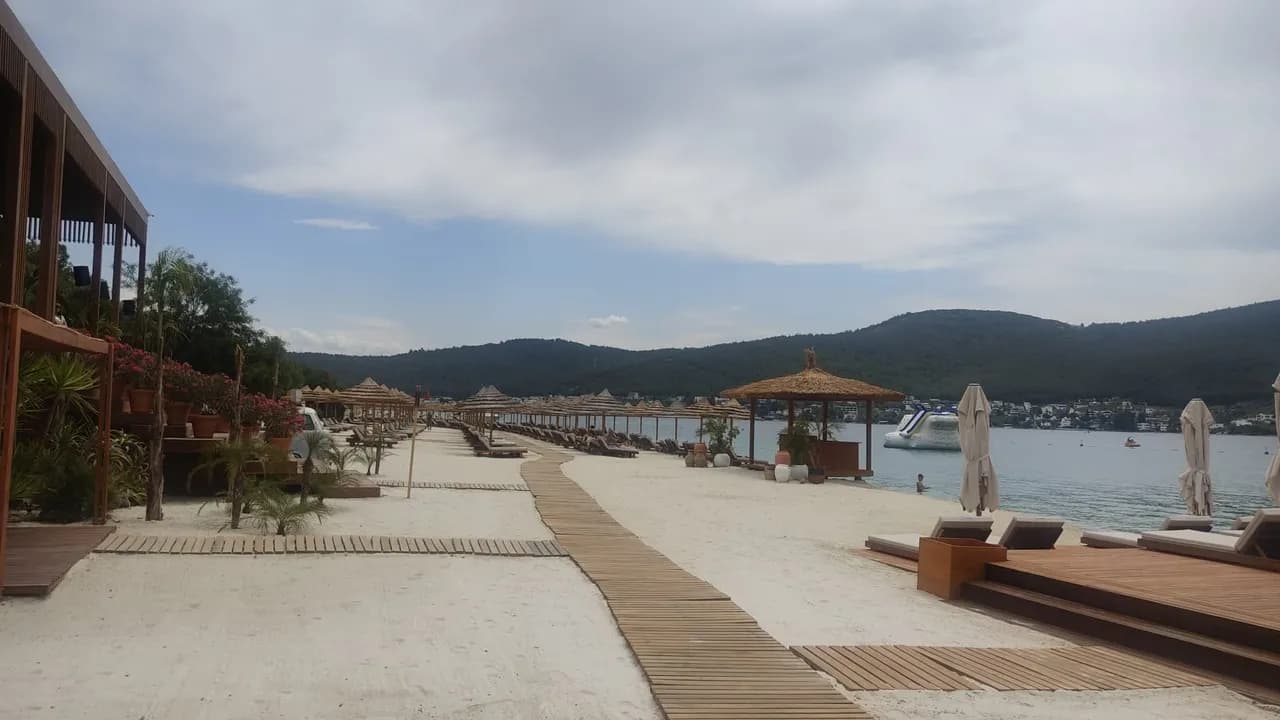 Silis kumu ile döşenmiş otel plajı — deniz kenarı şezlong alanı